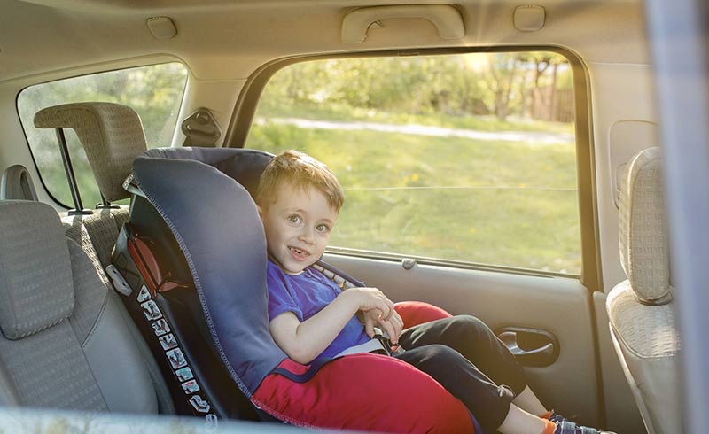 Boy smiles from car seat.