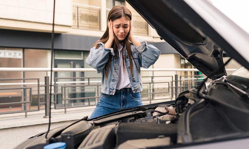 What To Know About The Indiana Lemon Law (2025) 1 woman stresses next to broken down car