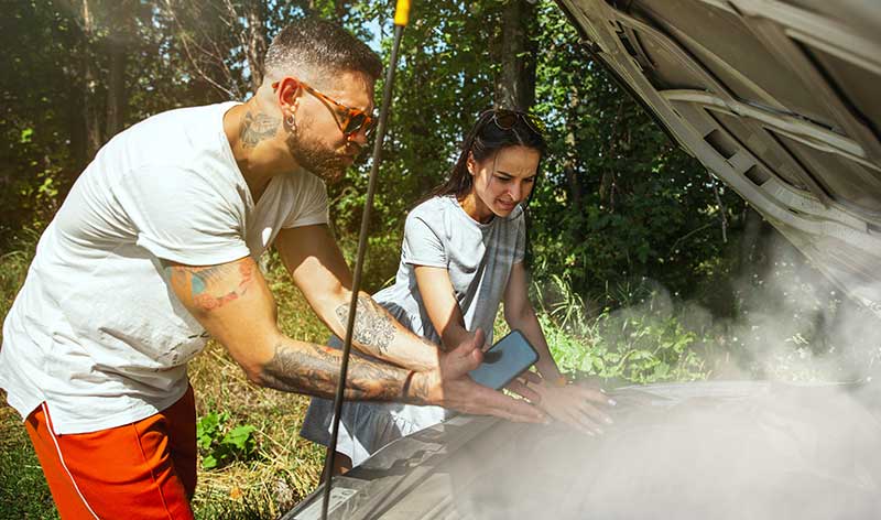 a man and woman work on car engine