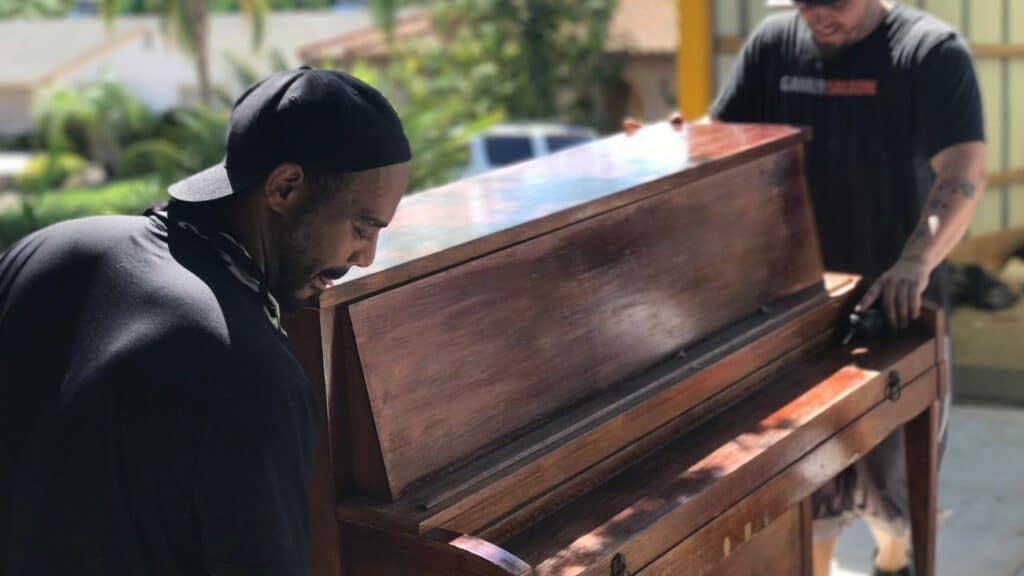 guys moving a piano into truck